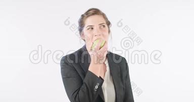 一个女人在白色的工作室里吃一个<strong>大苹果</strong>